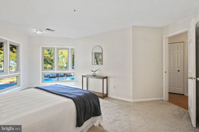 a bedroom with a bed a table and window