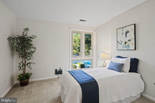 a bedroom with bed and a potted plant