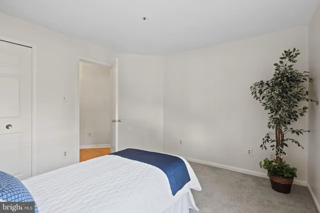 a bedroom with a bed and a potted plant