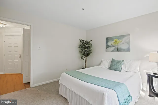 a bedroom with a bed and a potted plant