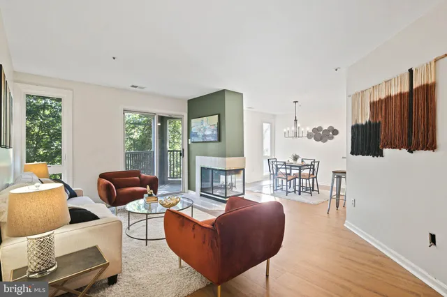 a living room with furniture fireplace and large windows