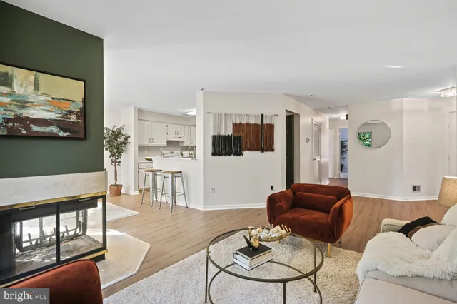 a living room with furniture kitchen view and a large window