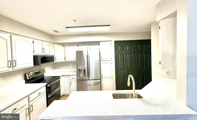a kitchen with a refrigerator a stove top oven and a sink