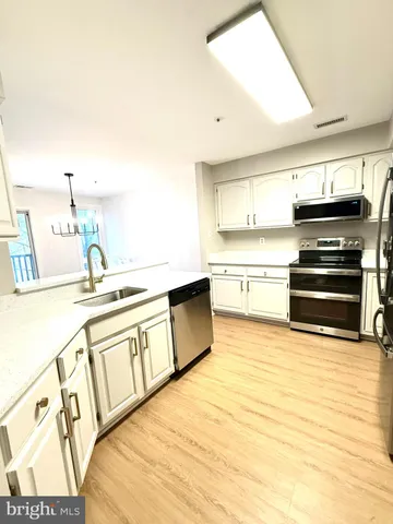 a view of a kitchen with kitchen island and stainless steel appliances