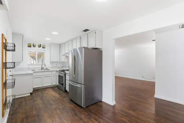 a kitchen with a refrigerator and a stove top oven