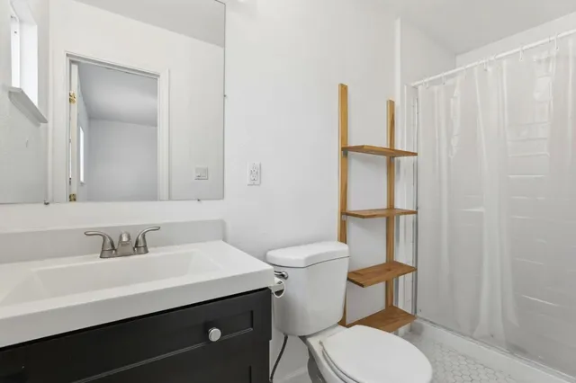 a bathroom with a toilet and a shower curtain