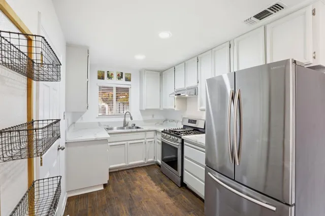 a kitchen with stainless steel appliances a refrigerator and a sink