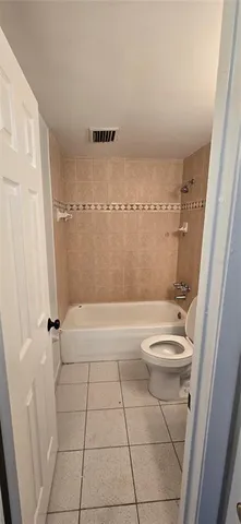 a bathroom with a granite countertop bathtub shower and toilet