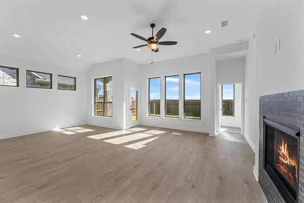 a view of an empty room with window and wooden floor