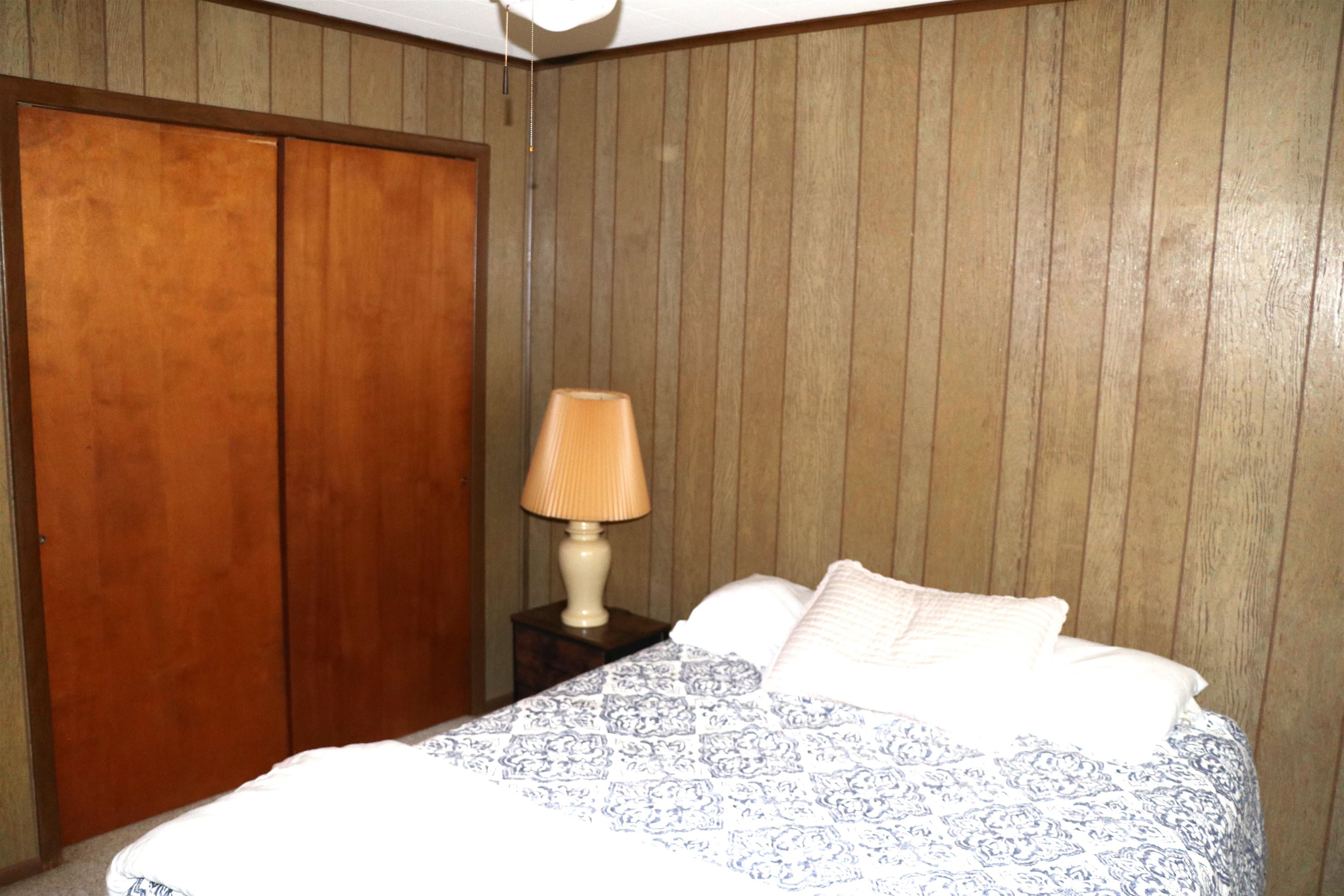 160 Patrick Drive Springville, TN 38256 - Photo 13 of 34 Wood paneling accentuates this interior space, featuring a built-in closet with double sliding doors