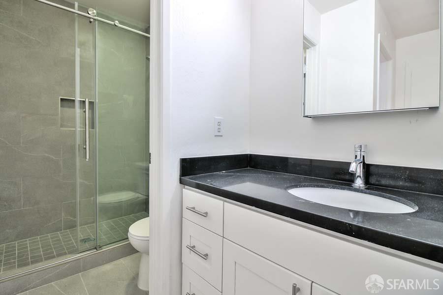 46728 Crawford Street, Unit 3 Fremont, CA 94539 - Photo 12 of 22 a bathroom with a granite countertop sink a toilet and shower