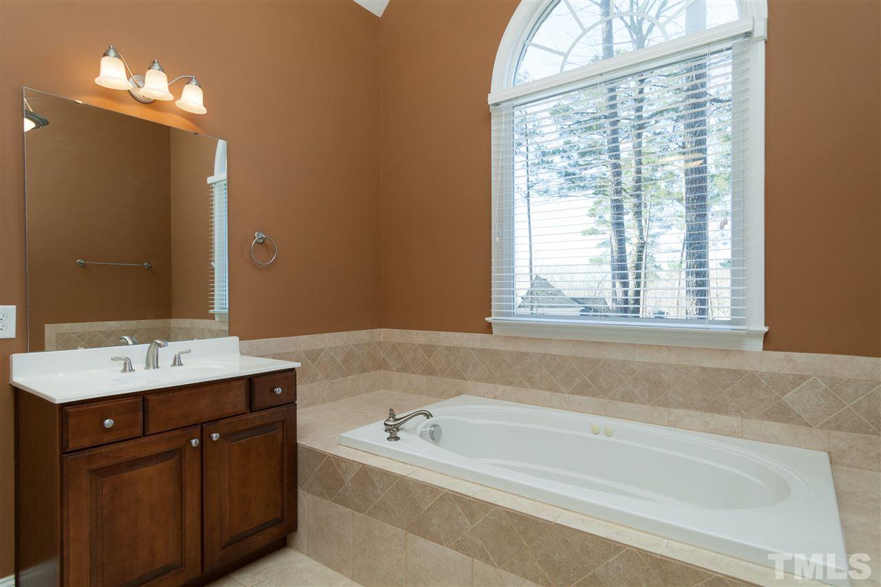 7217 Duncans Ridge Way Fuquay-Varina, NC 27526 - Photo 12 of 25 a bath room with a sink vanity tub and a mirror