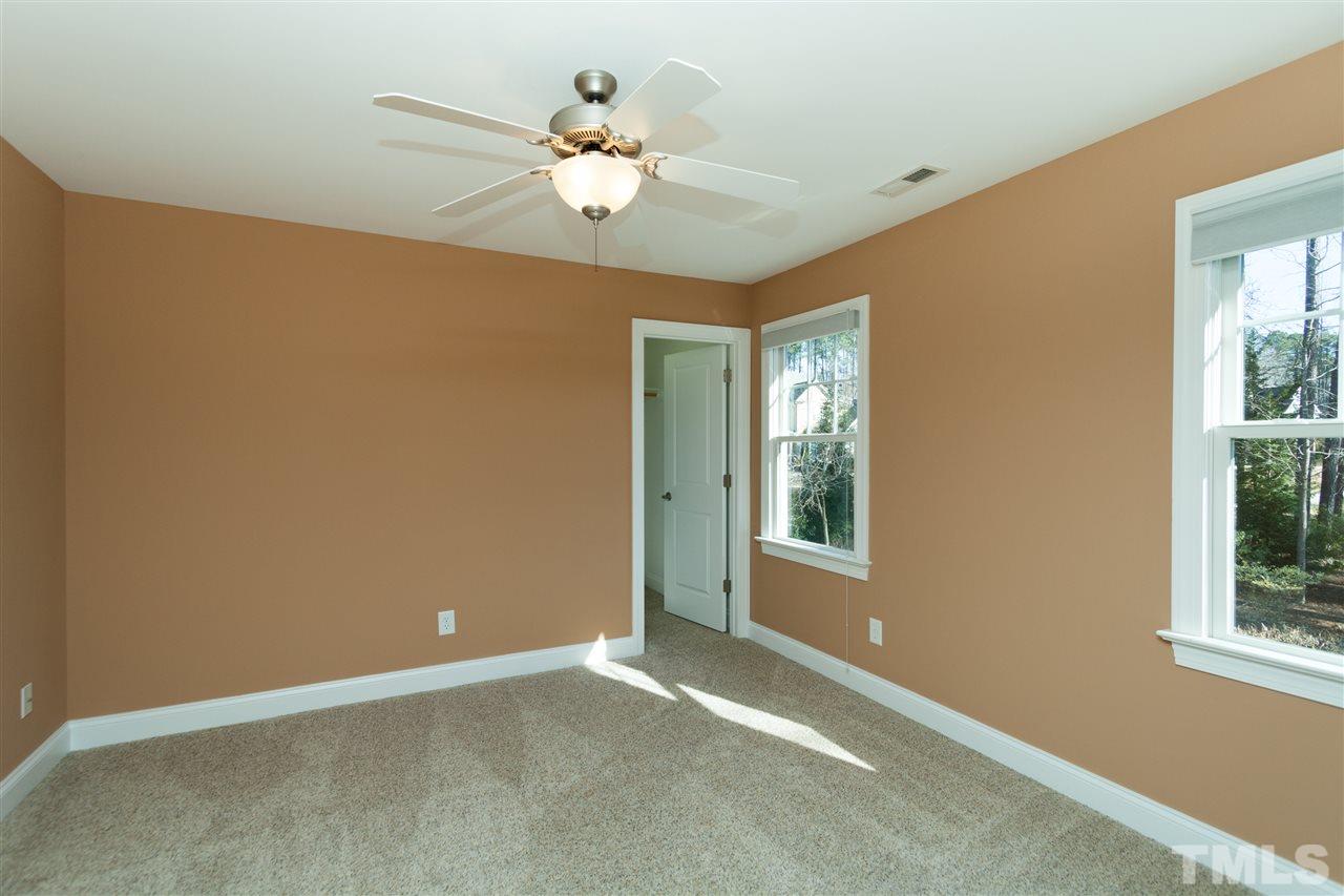 7217 Duncans Ridge Way Fuquay-Varina, NC 27526 - Photo 18 of 25 a view of an empty room with chandelier fan and fire place