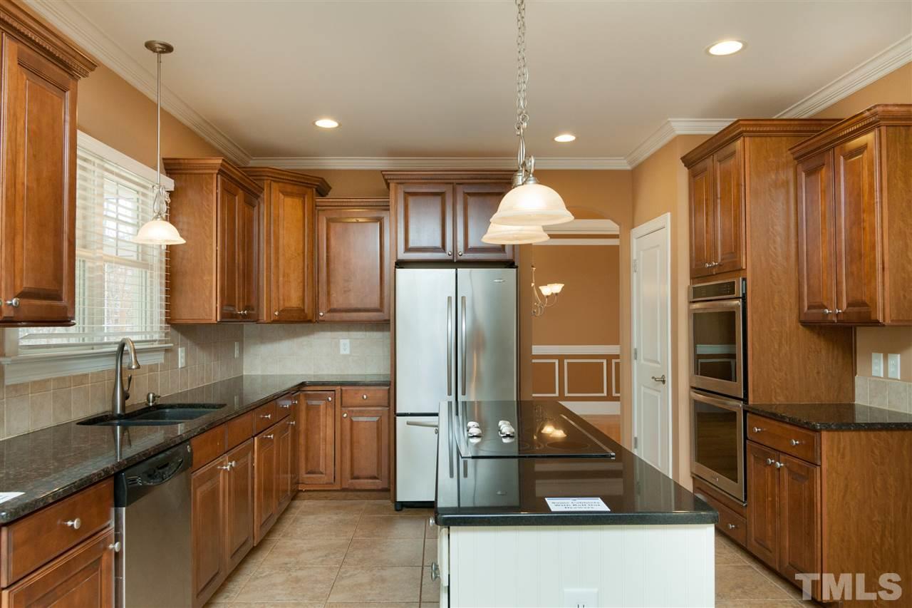 7217 Duncans Ridge Way Fuquay-Varina, NC 27526 - Photo 5 of 25 a kitchen with stainless steel appliances granite countertop a sink and a refrigerator