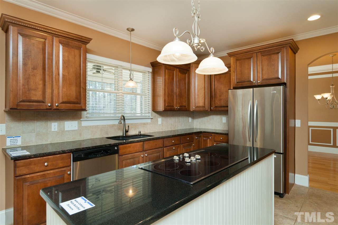 7217 Duncans Ridge Way Fuquay-Varina, NC 27526 - Photo 6 of 25 a kitchen with stainless steel appliances granite countertop a sink refrigerator and cabinets