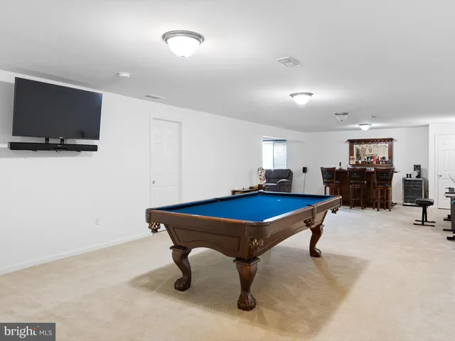 a room with furniture pool table and flat screen tv