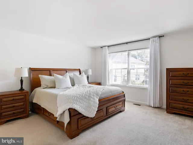 a spacious bedroom with a bed and a window