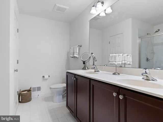 a bathroom with a double vanity sink toilet and a mirror