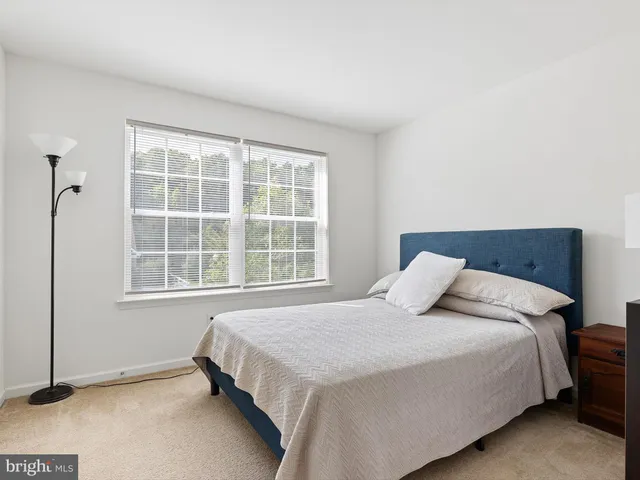 a bedroom with a bed and next to a window
