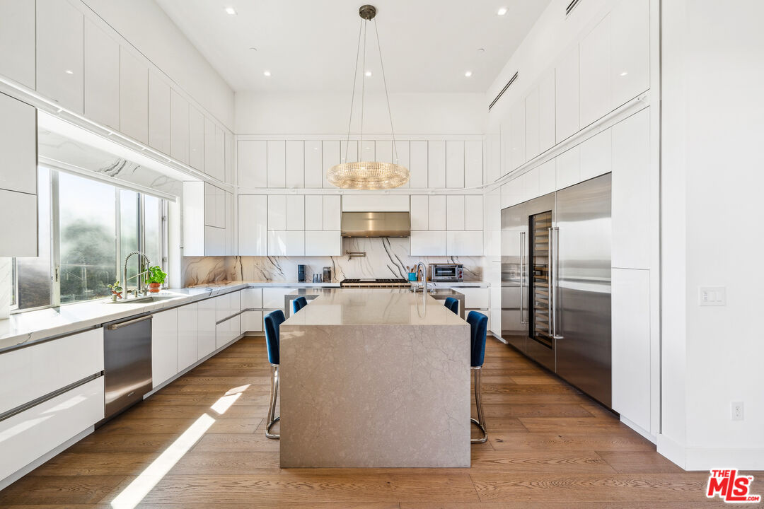 10715 Yerba Buena Road Malibu, CA 90265 - Photo 14 of 32 a large kitchen with kitchen island a large counter top stainless steel appliances and windows
