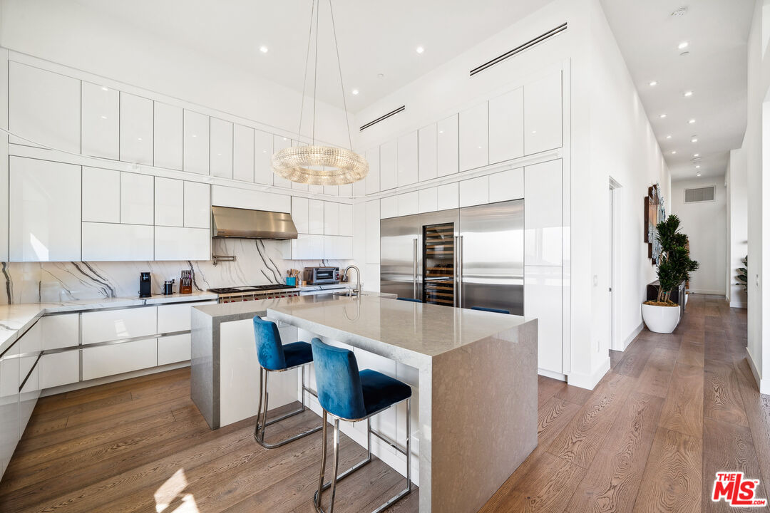 10715 Yerba Buena Road Malibu, CA 90265 - Photo 15 of 32 a large kitchen with cabinets wooden floor and stainless steel appliances