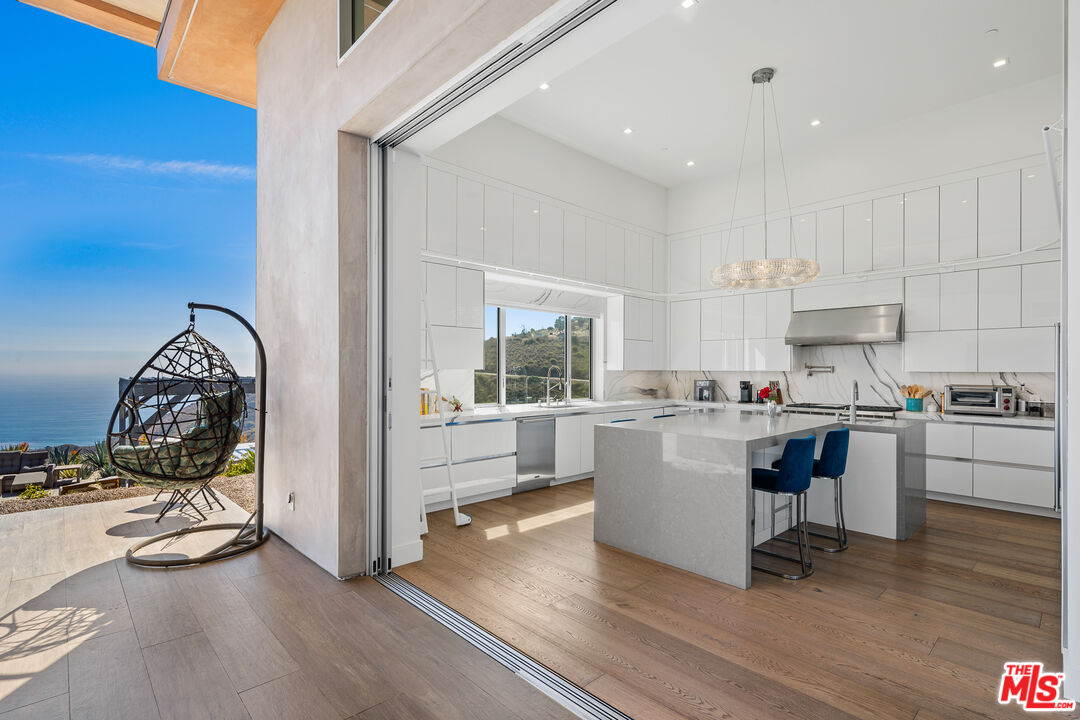10715 Yerba Buena Road Malibu, CA 90265 - Photo 16 of 32 a kitchen with a sink a stove cabinets and wooden floor