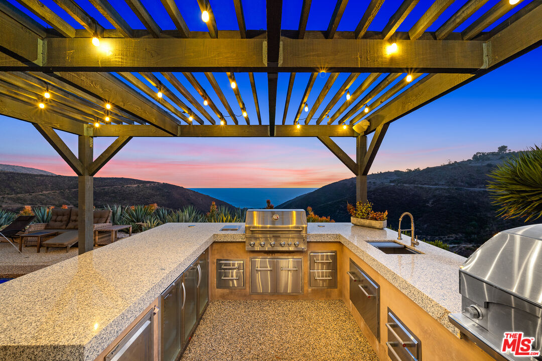 10715 Yerba Buena Road Malibu, CA 90265 - Photo 23 of 32 a view of an outdoor kitchen and swimming pool