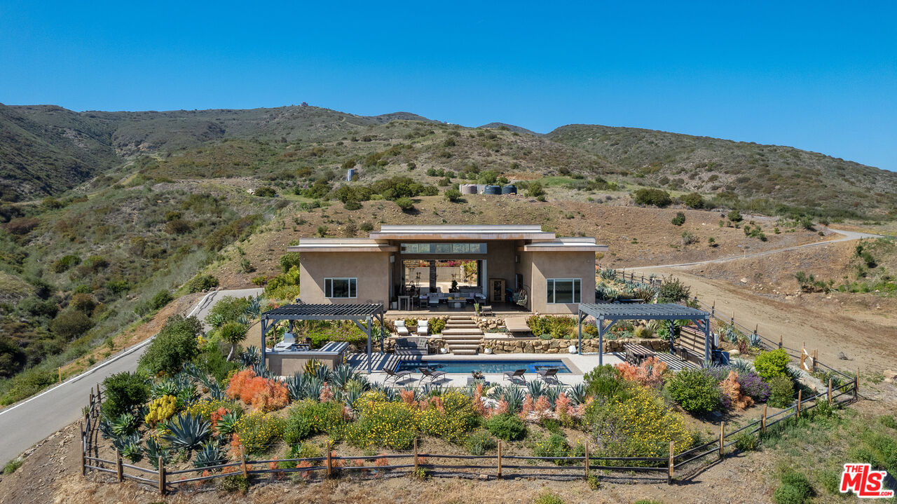 10715 Yerba Buena Road Malibu, CA 90265 - Photo 7 of 32 a front view of house with yard and mountain in the background