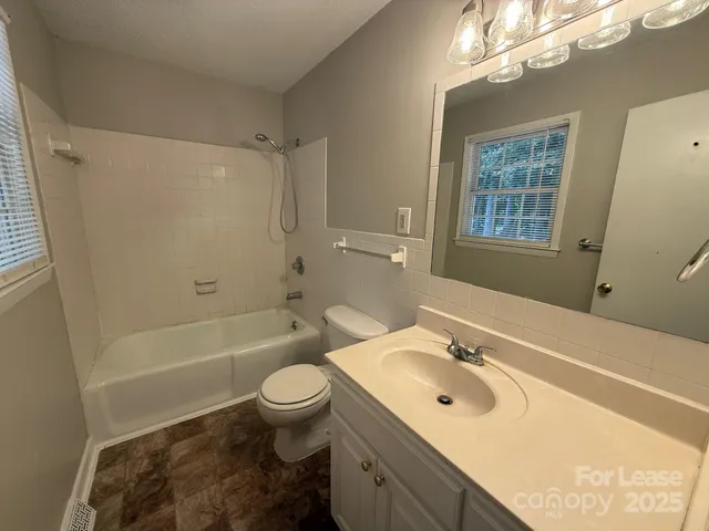 a bathroom with a sink a toilet a mirror a bathtub and shower
