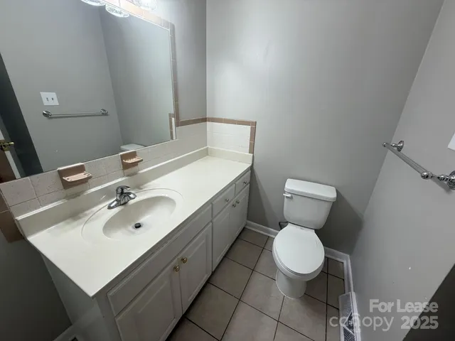 a bathroom with a sink mirror vanity and toilet