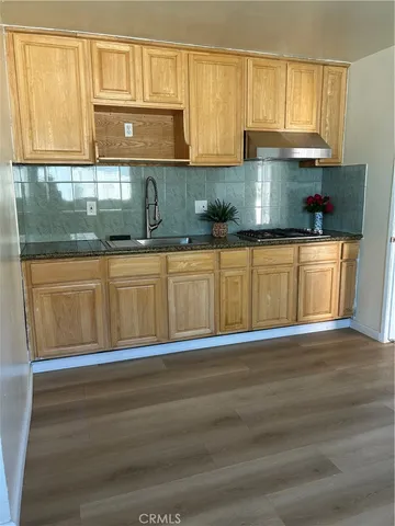 a kitchen with granite countertop a sink and a stove