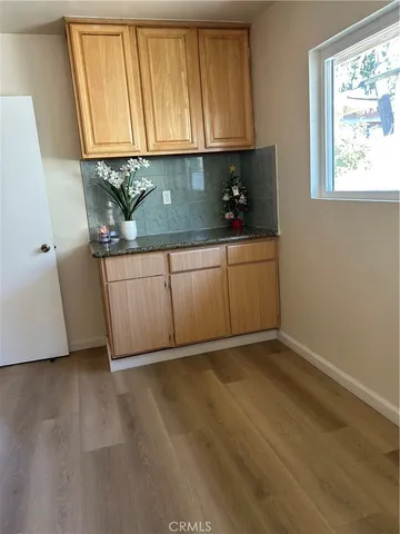 a kitchen with granite countertop a sink a window and cabinets