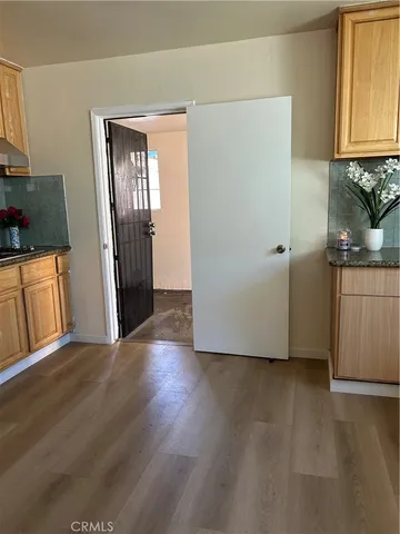 a view of a kitchen with wooden floor and cabinets