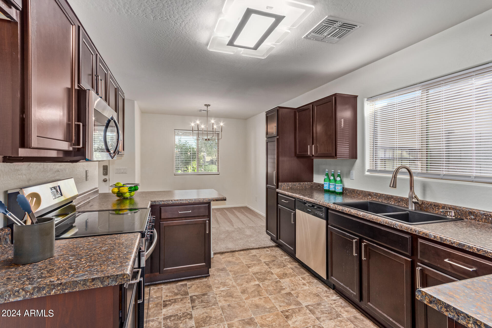 1832 South Hayley Road Apache Junction, AZ 85119 - Photo 3 of 30 a kitchen with stainless steel appliances granite countertop sink stove top oven and cabinets