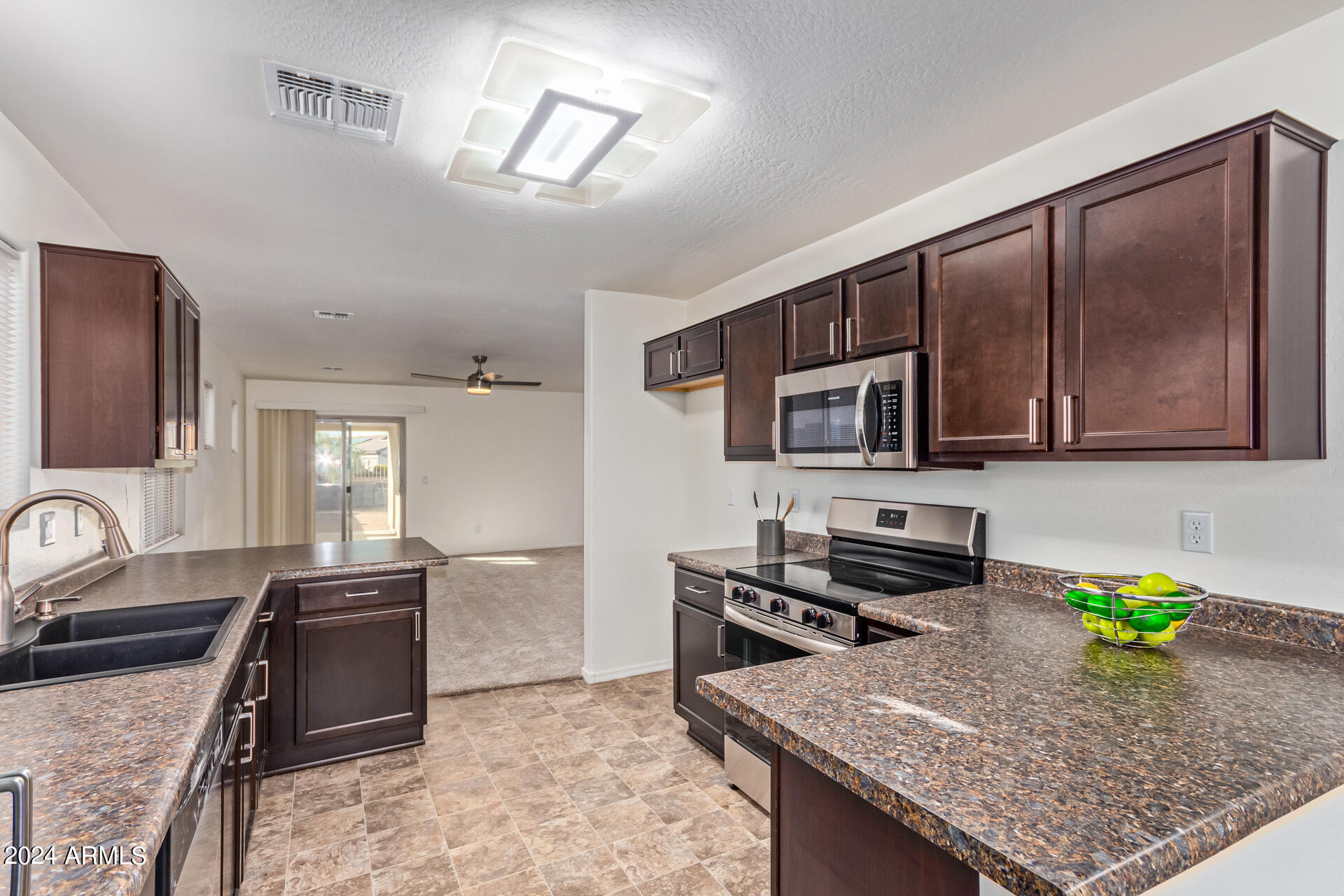 1832 South Hayley Road Apache Junction, AZ 85119 - Photo 10 of 30 a kitchen with stainless steel appliances granite countertop a sink stove and refrigerator