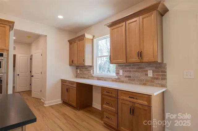 a kitchen with stainless steel appliances granite countertop a sink a stove cabinets and wooden floor