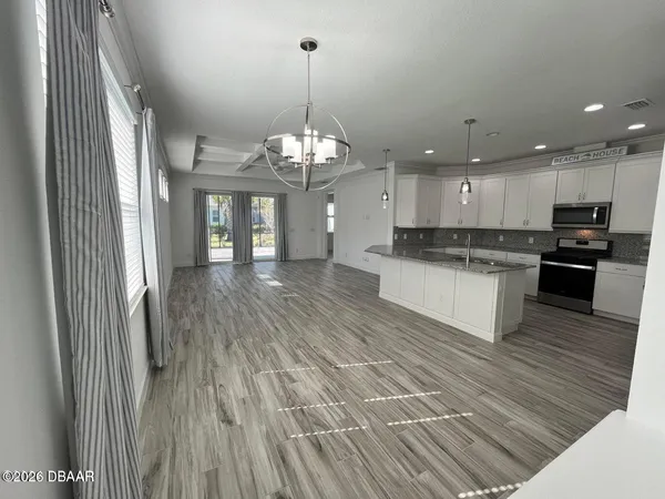 a large kitchen with stainless steel appliances granite countertop a oven a stove and a wooden floors