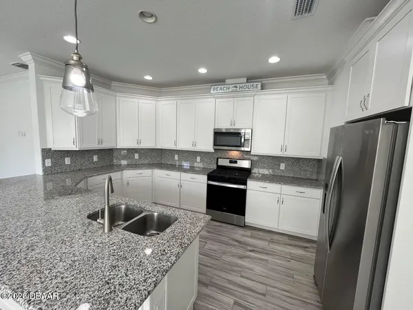 a kitchen with stainless steel appliances granite countertop a refrigerator sink and stove