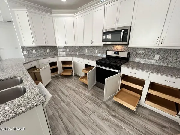 a kitchen with granite countertop a stove and cabinets
