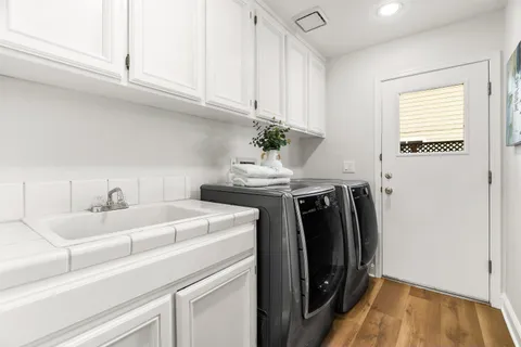 a bathroom with a granite countertop bathtub shower sink vanity and toilet