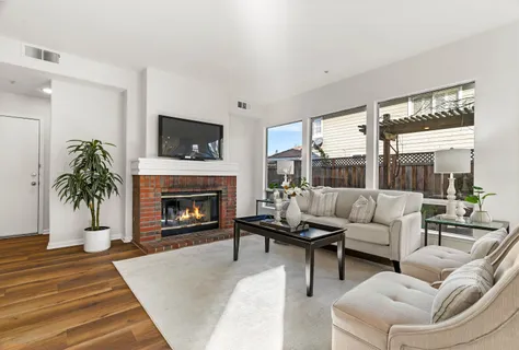 a living room with furniture a flat screen tv and a fireplace