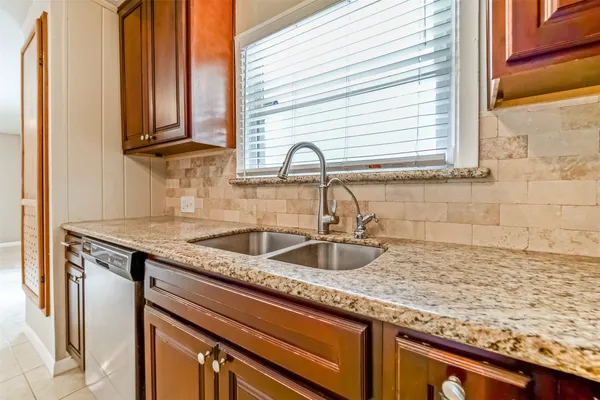 a kitchen with granite countertop a sink and a window