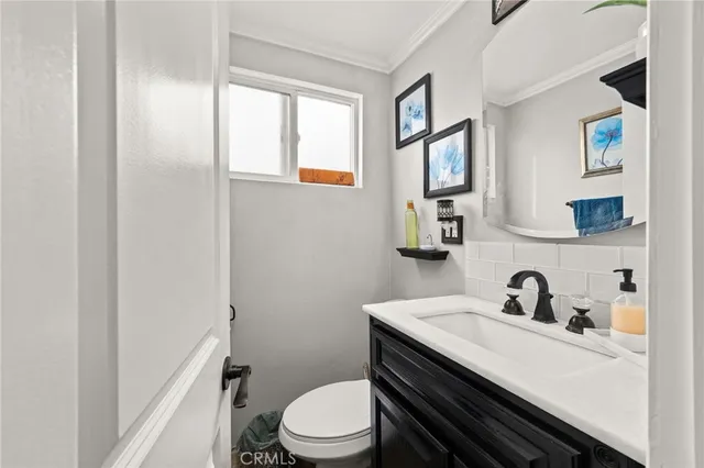 a bathroom with a sink vanity mirror and toilet
