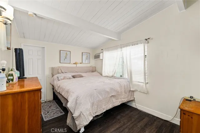 a bedroom with a bed and a flat tv screen on the dresser