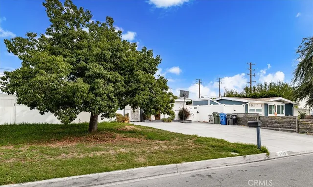 a view of a yard with plants and a bench