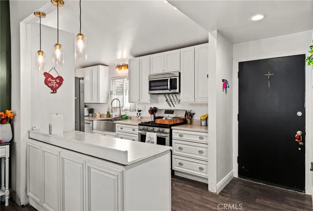 a kitchen with granite countertop a sink cabinets and stainless steel appliances