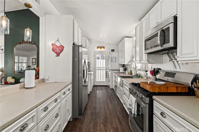 a kitchen with stainless steel appliances granite countertop a lot of counter space and wooden floors