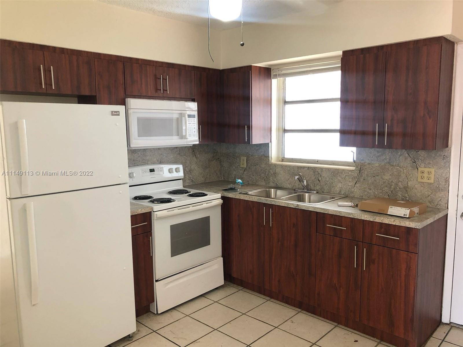 1709 Northwest 22nd Court Miami, FL 33125 - Photo 2 of 7 a kitchen with a stove sink and cabinets