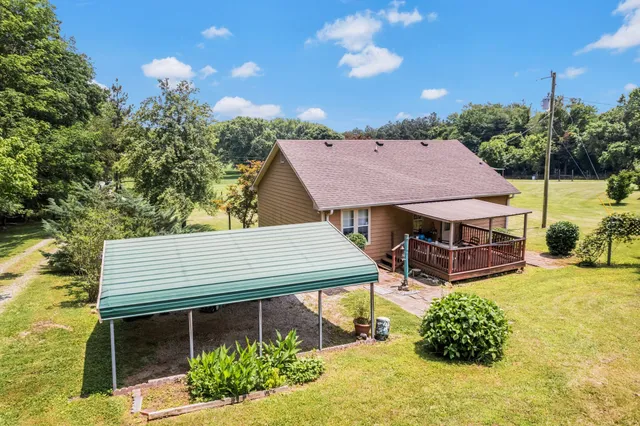a aerial view of a house with table and chairs under an umbrella