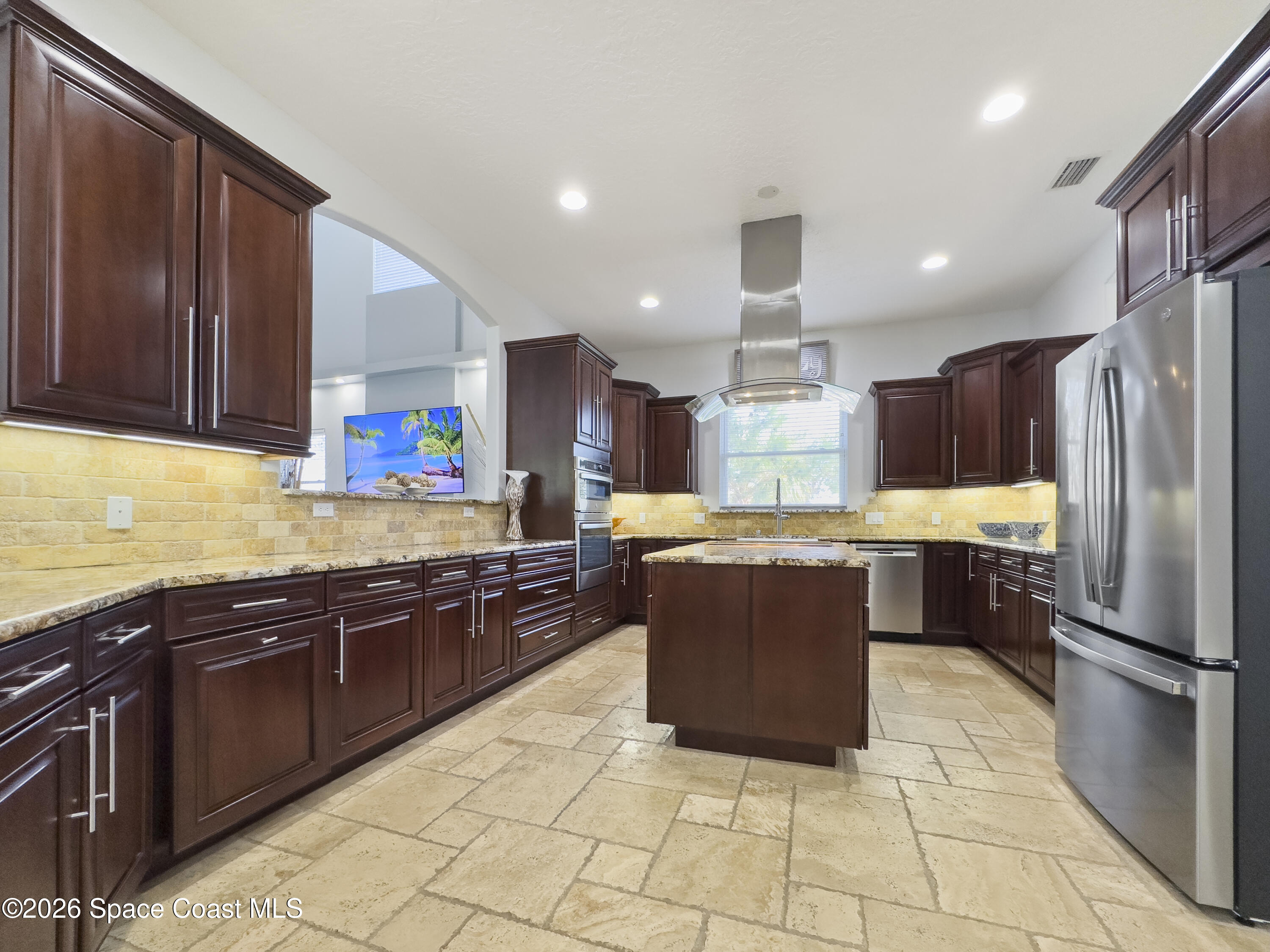 4762 Blossom Ridge Place Grant, FL 32949 - Photo 12 of 42 a kitchen with kitchen island granite countertop wooden cabinets and stainless steel appliances